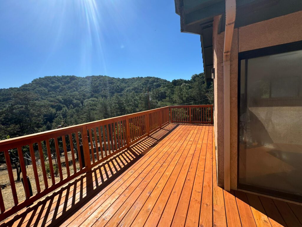 A spacious wooden deck with a view of lush green hills, exemplifying Bayside Builders Group’s expertise in crafting outdoor living spaces in the Bay Area.